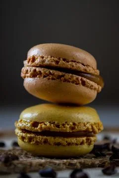 Two small colored macaroons on a dark background Stock Photos