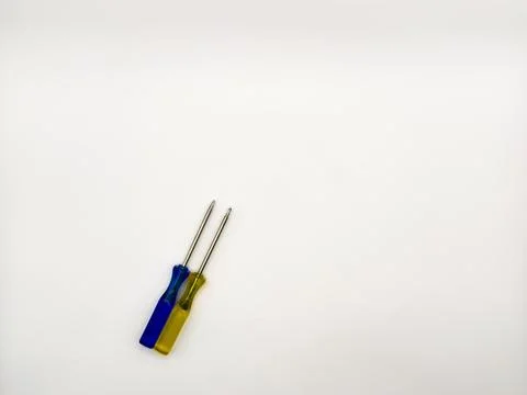 Two small colored plastic screwdrivers on a white background, blue and yellow. Stock Photos