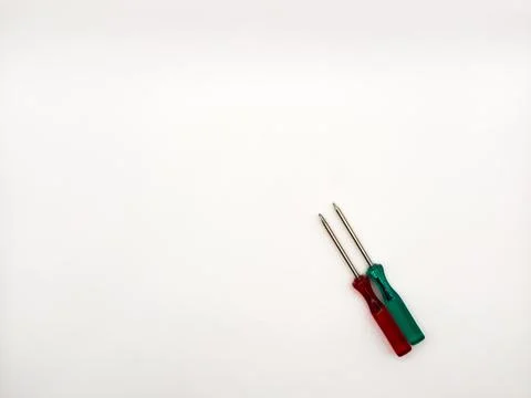 Two small colored plastic screwdrivers on a white background, red and green. Stock Photos