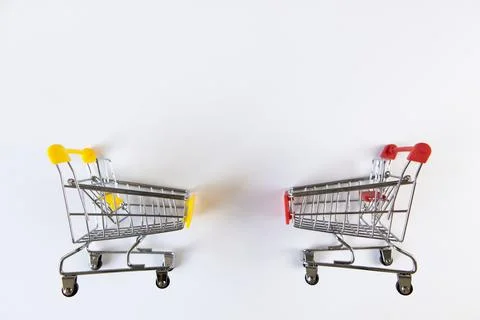 Two small empty decorative shopping carts with yellow, red accents on white b Stock Photos