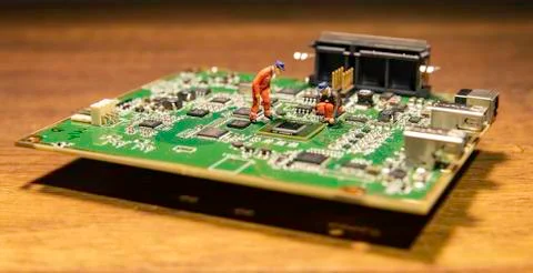 Two small engineers model fixing on circuits board Stock Photos