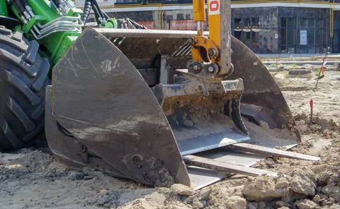 Two small excavators on a large construction site. Bright green on wheels and Stock Photos