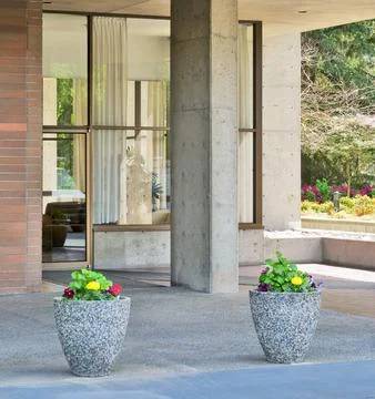Two small flower beds in front of residential building entrace Stock Photos