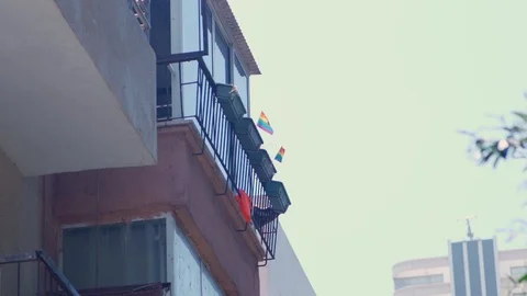Two small Gay pride flags waving in the wind on top of a balcony in Tel Aviv Stock Footage 110625951