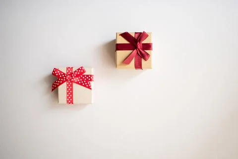 Two small gift boxes with tied decorative bow and red ribbon Stock Photos
