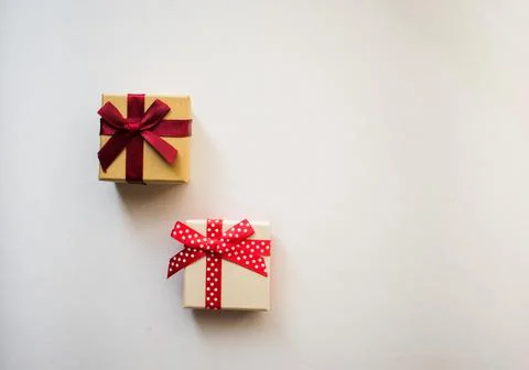 Two small gift boxes with tied decorative bow and red ribbon Stock Photos