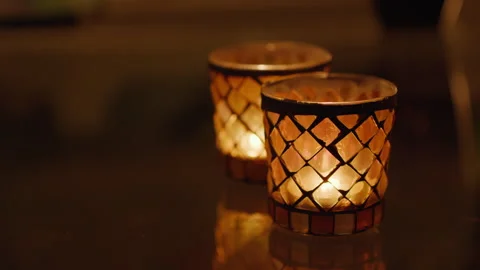 Two small glass candlesticks with a diamond pattern with flickering flames Stock Footage 269230396
