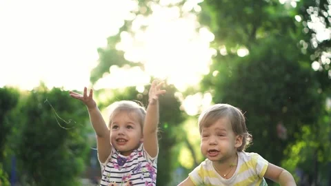 Two small kids siblings playing in the park against the sunset Stock Footage 130580174