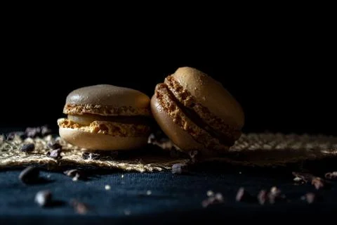 Two small multi-colored macaroons on a dark background, a sweet treat Foto stock