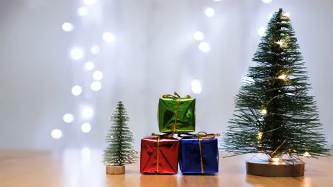 Two small pine trees in the foreground and gift packages arranged one above the Vídeo Stock 142767692