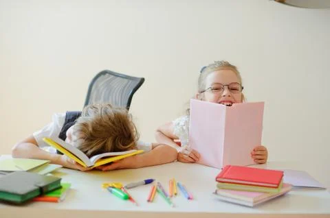 Two small pupil primary school, boy and girl, doing lessons. Stock Photos