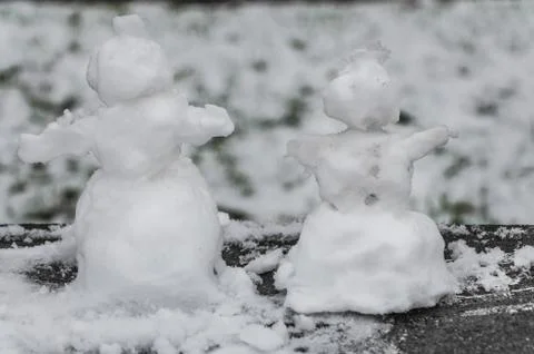 Two small rough snowmen with snow is on the black and white photo Stock Photos