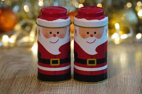Two small round Santa Clause tins infront of Christmas lights Stock Photos