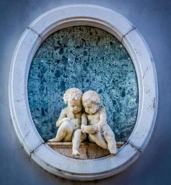 Two small stone angels wtih a cup Stock Photos