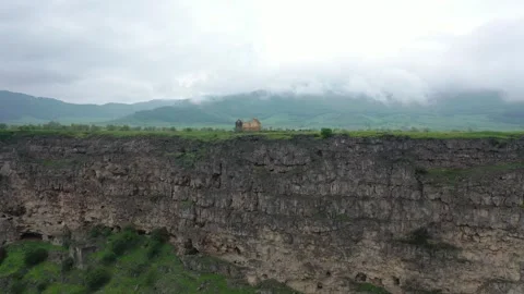 Two small stone building on the edge of plato with fog and cloudy weather 動画素材 252598815