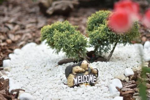Two small toy hedgehogs hold a welcome sign Stock Photos