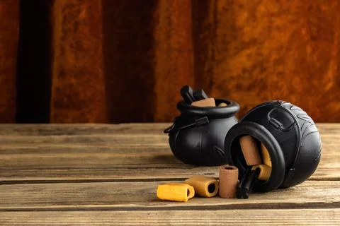 Two small toy witches' cauldrons with different candies stand on a wooden tab Stock Photos