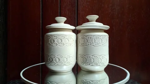 Two small white ceramic pieces resembling lidded cylinders Stock Footage 341306794