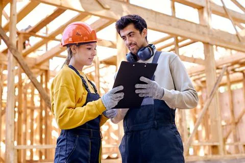 Two smart architects constructors holding clipboard blueprints at construction Stock Photos