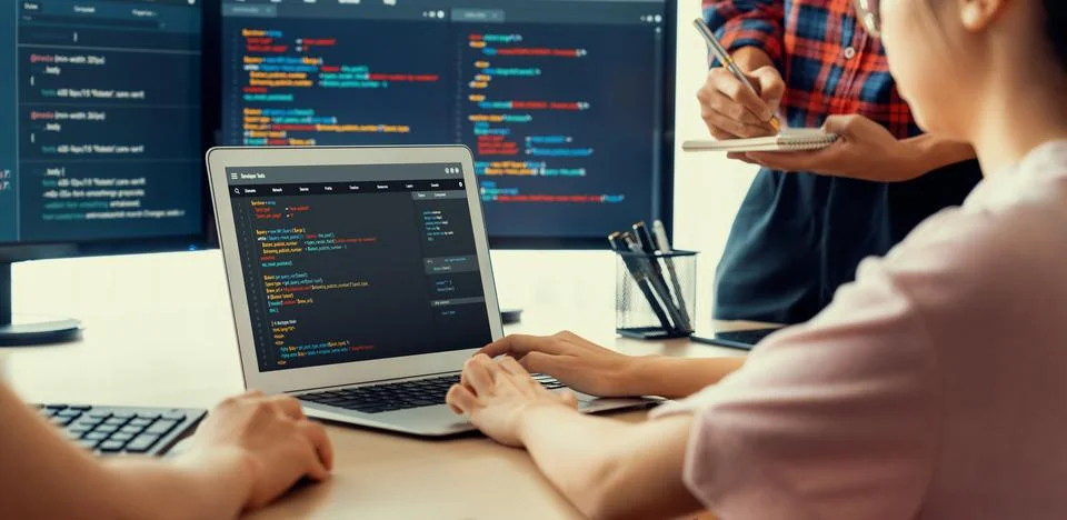 Two smart computer engineers working together to solve program code. Burgeoning. Photos