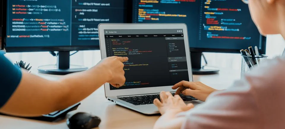 Two smart computer engineers working together to solve program code. Burgeoning. Stock-Fotos