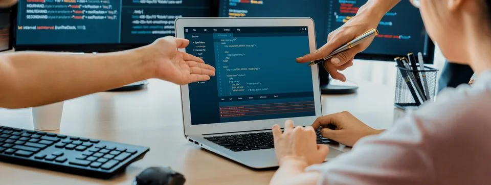 Two smart computer engineers working together to solve program code. Burgeoning. Stock-Fotos