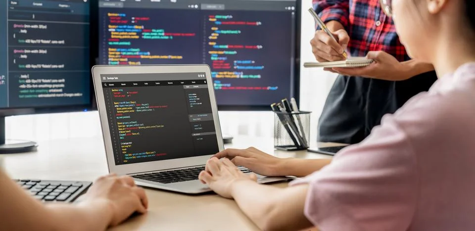 Two smart computer engineers working together to solve program code. Burgeoning. Stock Photos