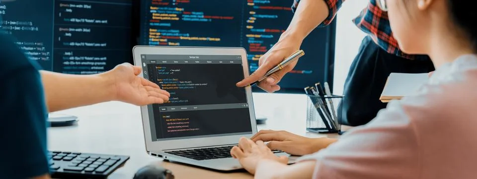 Two smart computer engineers working together to solve program code. Burgeoning. Stock Photos
