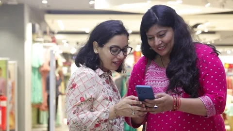Two smart women using mobile phone advanced technology standing. Stock Footage 245296480