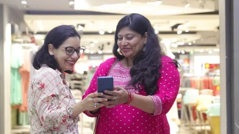 Two smart women using mobile phone advanced technology standing. Stock Footage 245296486