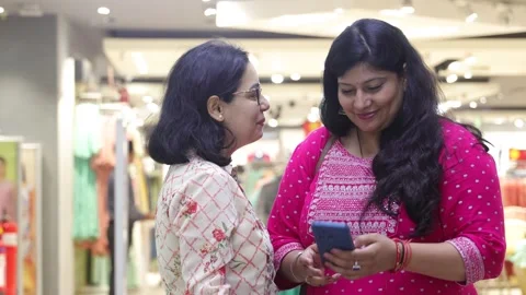 Two smart women using mobile phone advanced technology standing. Stock Footage 245296498