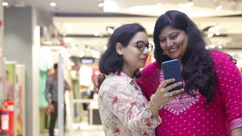Two smart women using mobile phone advanced technology standing. Stock Footage 245296511