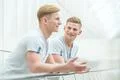 The two smile brother stand on the office balcony and gesture Photo