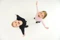The two smile children stand on the white background. View from above Photo