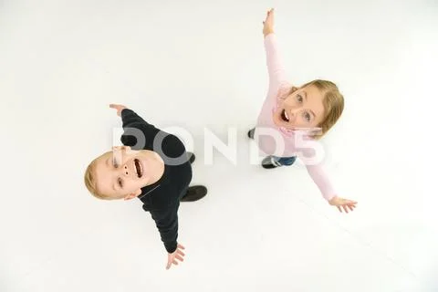 The two smile children stand on the white background. View from above Stock Photos