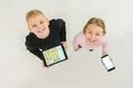 The two smile kids stand with devices. View from above Photo