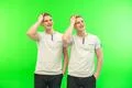 The two smile twin brother gesture on the green background Photo