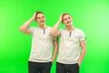 The two smile twin brother gesture on the green background Photo