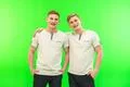 The two smile twin brother stand on the green background Photo