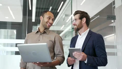 Two smiling businessmen communicate standing in business office. Male colleagues Stock Footage 309644049