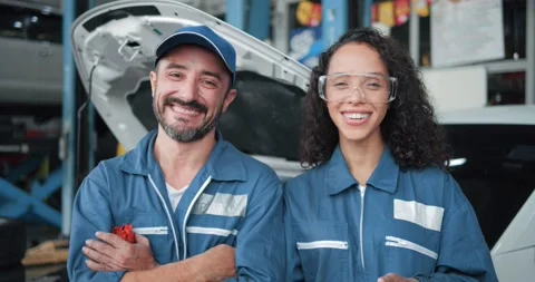 Two smiling car mechanic standing look at camera in garage Видео 157625386