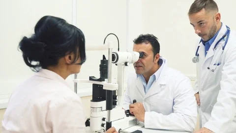 Two smiling doctors check the patients vision Stock Footage 80997999