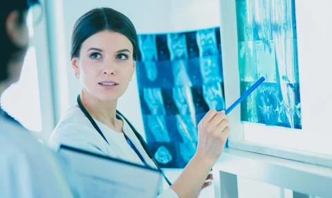 Two smiling doctors pointing at x-rays in a hospital consulting room Stock Photos