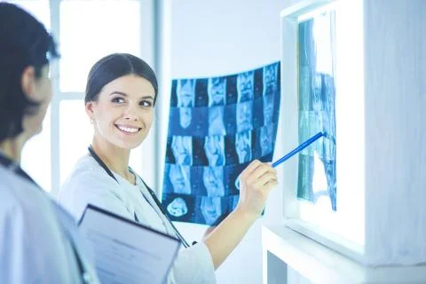 Two smiling doctors pointing at x-rays in a hospital consulting room Stock Photos