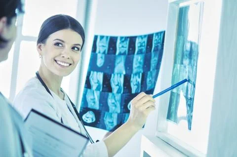 Two smiling doctors pointing at x-rays in a hospital consulting room Stock Photos