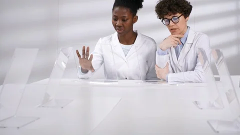 Two Smiling Female Scientists Discussing Simulations on Futuristic AR Devices Stock Footage 121573569