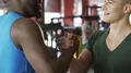 Two smiling friends saying goodbye after training in gym, friendly handshake HD Footage