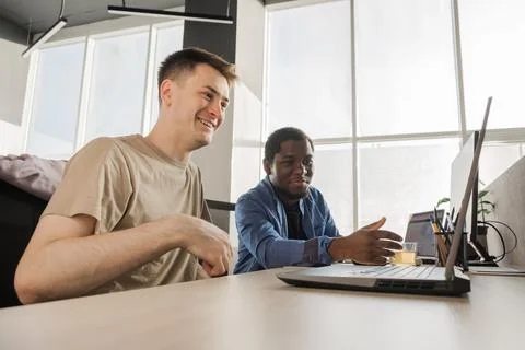 Two smiling positive programmers working in the office of a software development Stockfoto's