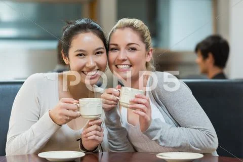 Two smiling students in college coffee shop Stock Photos