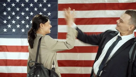 Two smiling students greeting each other on the background of the flag Stock Footage 119569716